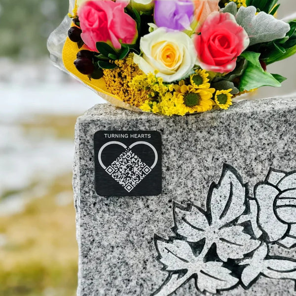Turning Hearts medallion on a headstone with roses