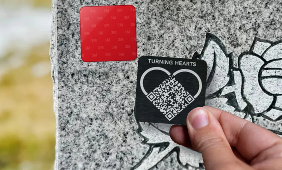 Pressing a Turning Hearts medallion onto the red 3M pad on a headstone